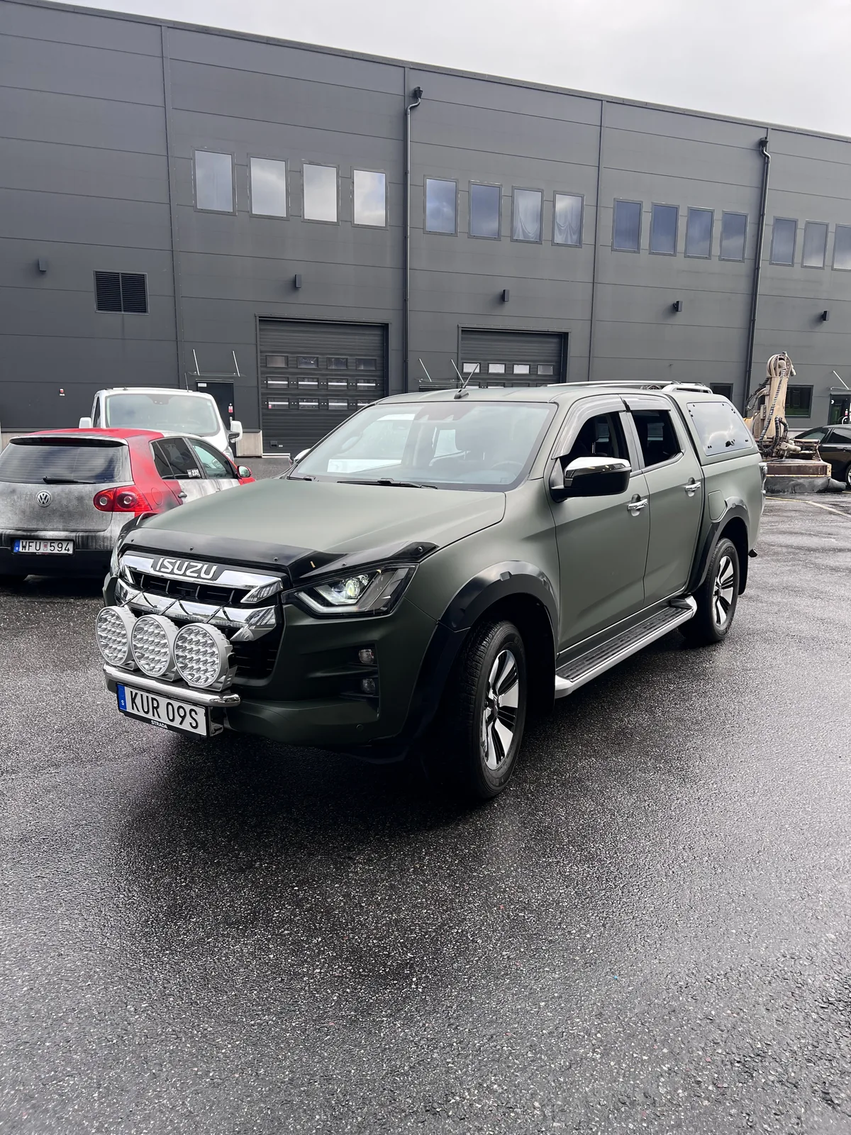 Mörkgrön pickup med ett nedtonat, enhetligt färguttryck.