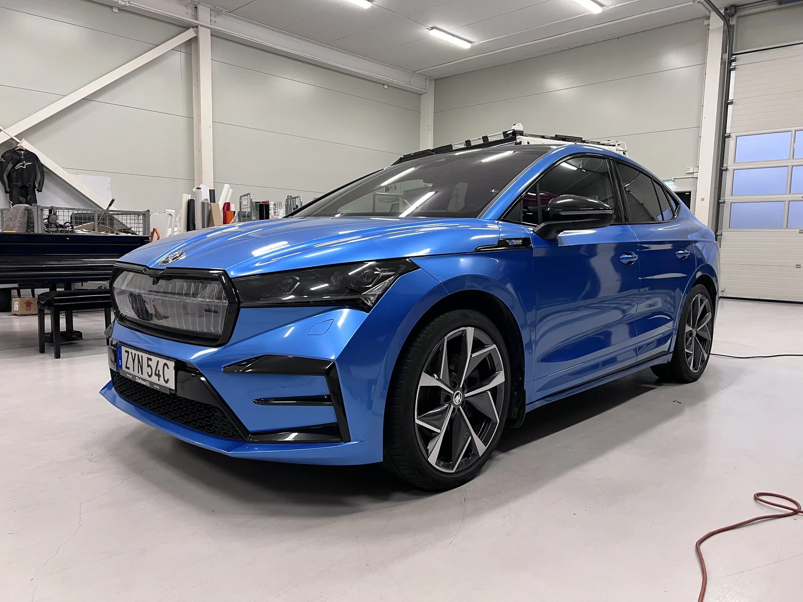 Klarblå SUV med mörka detaljer, fotograferad i verkstaden.