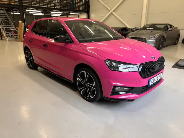Rosa Škoda med svart tak och mörka detaljer.