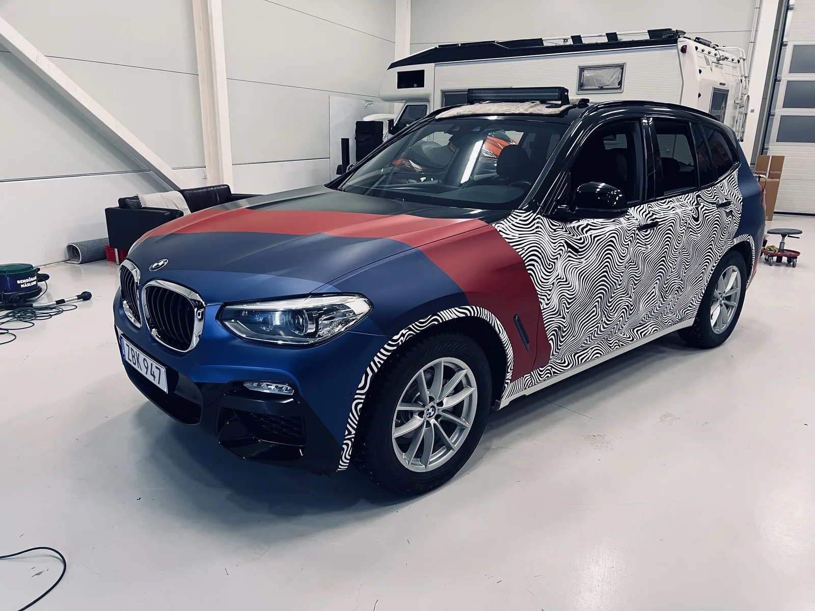 SUV med blå och röda fält kombinerade med ett vitt och svart linjemönster.