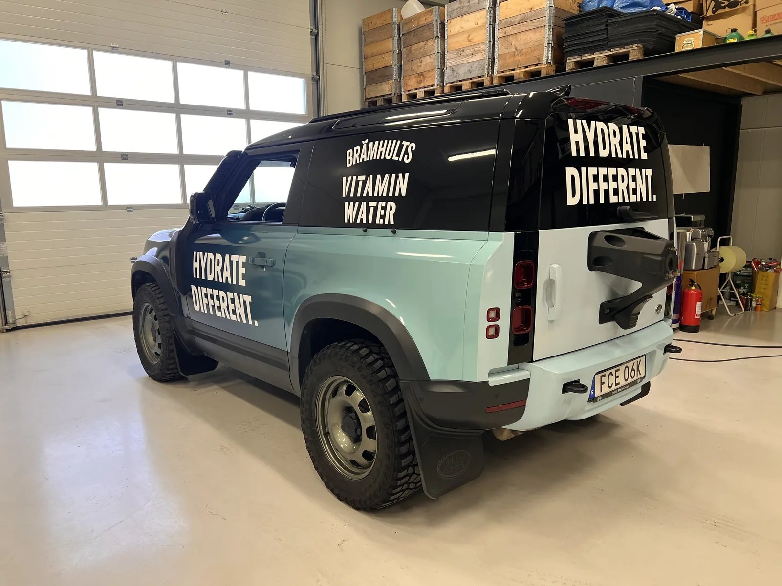 Tvåfärgad transportbil med Brämhults Vitamin Water-profilering.