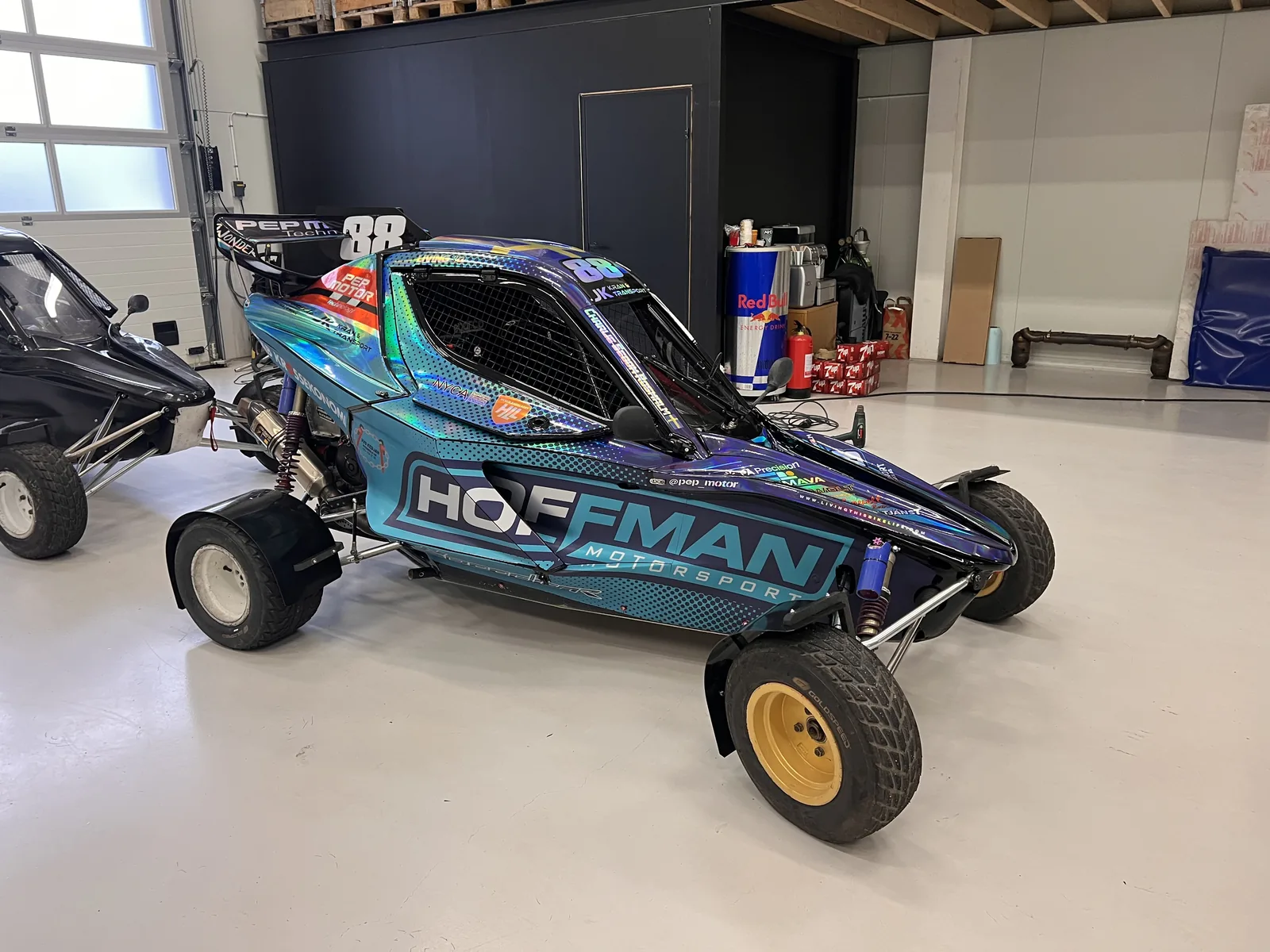 Tävlingsbuggy med färgskiftande grafik och stora dekaler.
