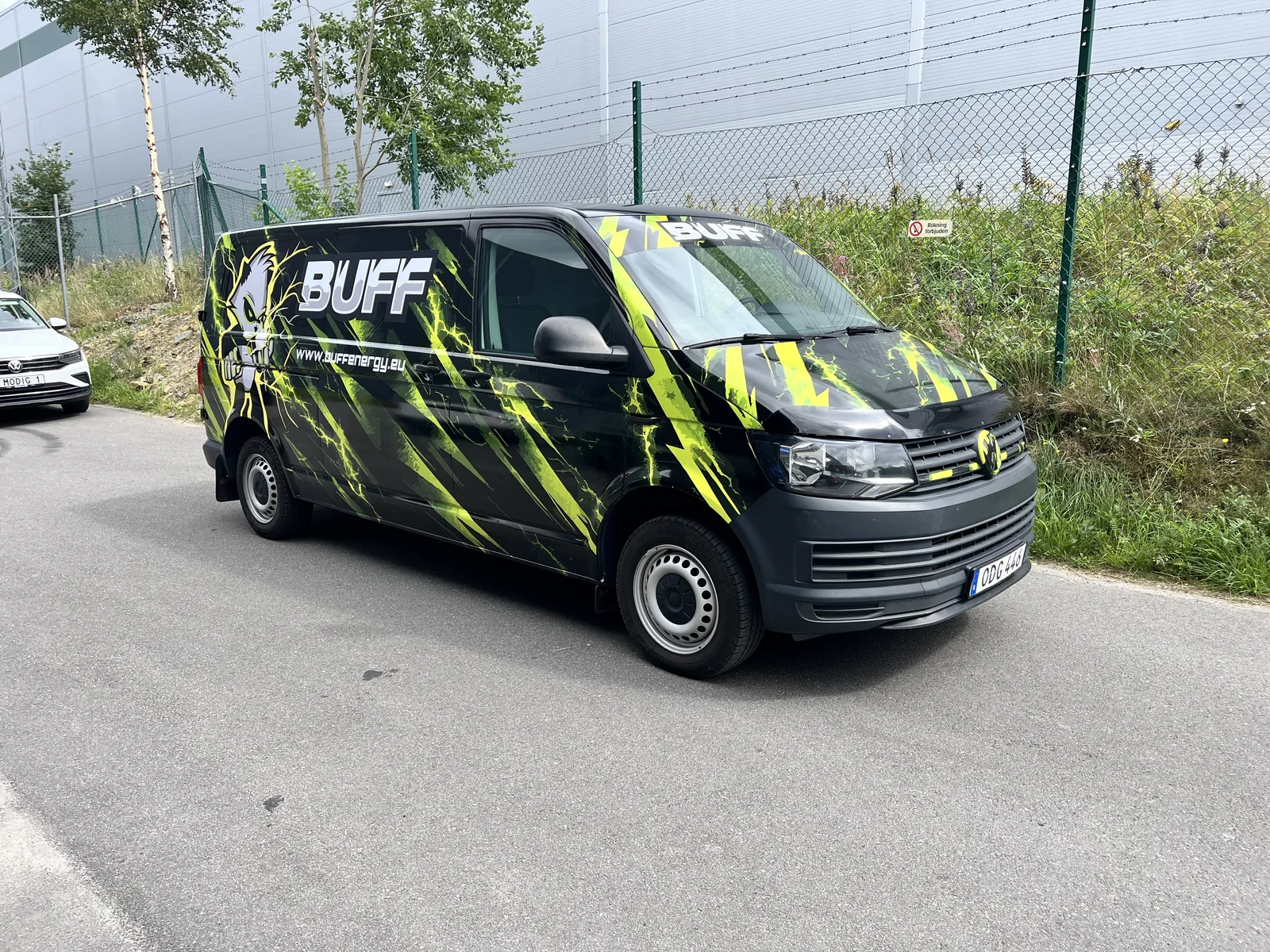 Svart transportbil med gulgrön grafik och BUFF-budskap.