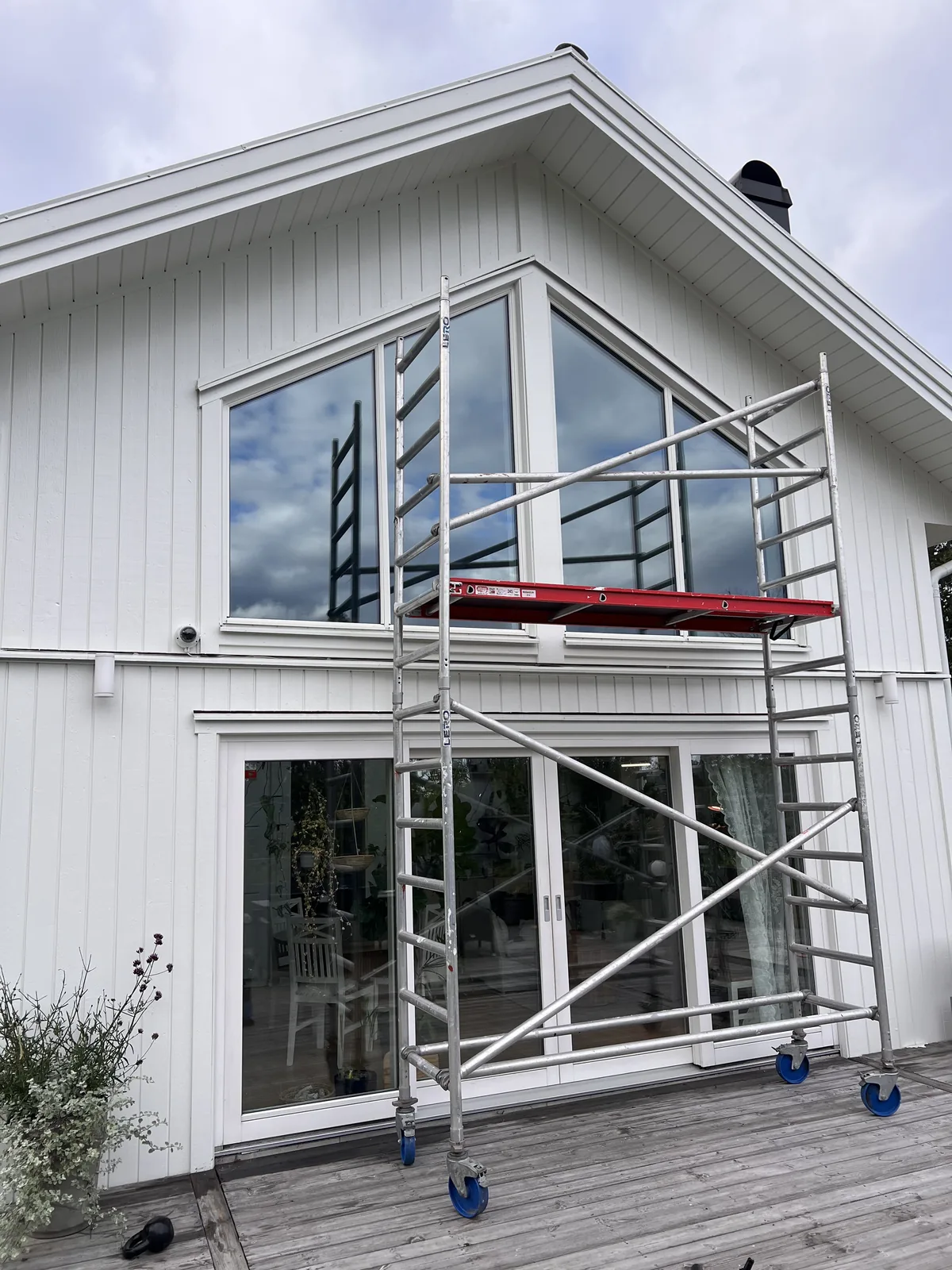 Stora fönsterpartier i en villa med ställning för montage.