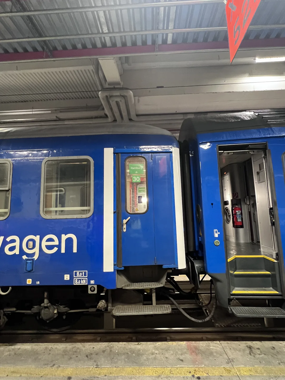 Blå dekor längs tågets sida, med utskärningar runt dörrar och fönster.